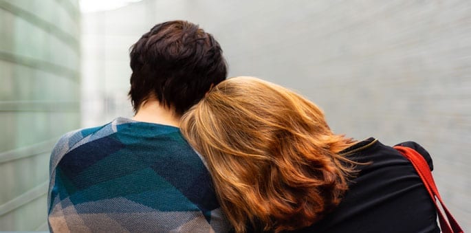 recovering addict leans on shoulder of support person